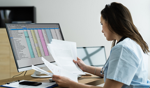 Worker dressed in scrubs doing paperwork