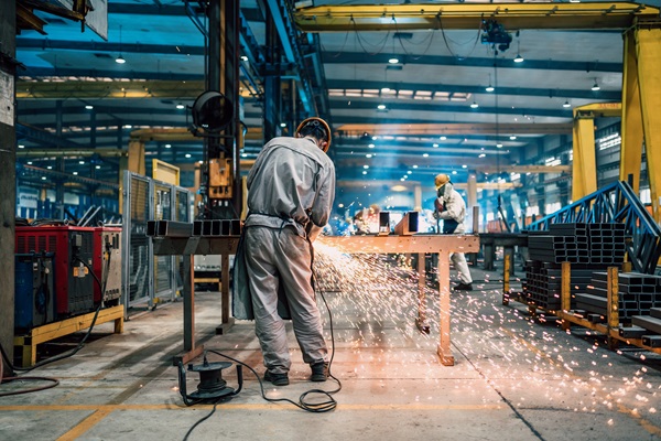 Factory worker using an angle grinder