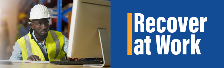 Recover at work - man in hard hat working at a desk in a warehouse