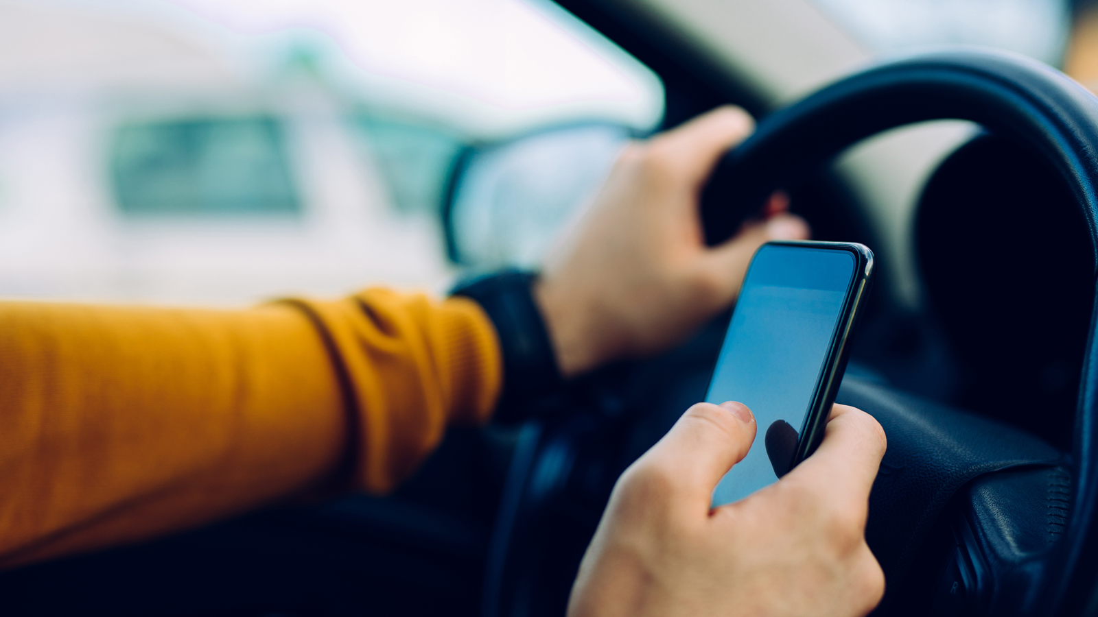 person using cell phone while driving