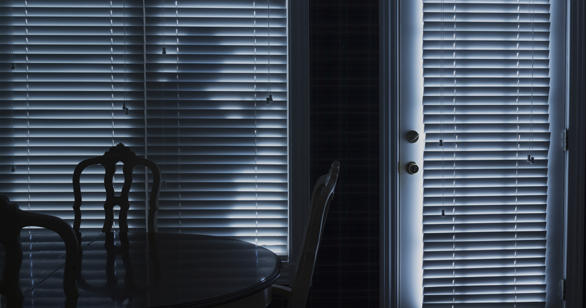 Inside of a dark home with someone outside. Text on image: 6 things to do before you go on vacation