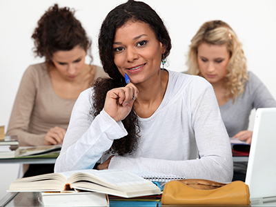 Three women sitting at desks and studying
