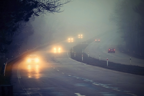 Distant headlights on a foggy road.
