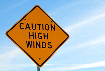 Road sign: caution, high winds.