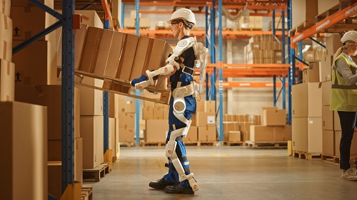 Warehouse worker lifting boxes while wearing an industrial exoskeleton
