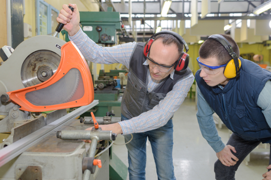 Workers using a circular saw with a machine guard