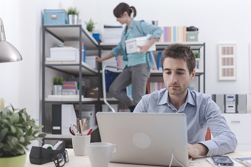 Office workers - man at a desk, woman on a step ladder