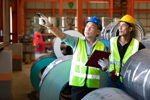 Warehouse workers in hard hats and safety vests