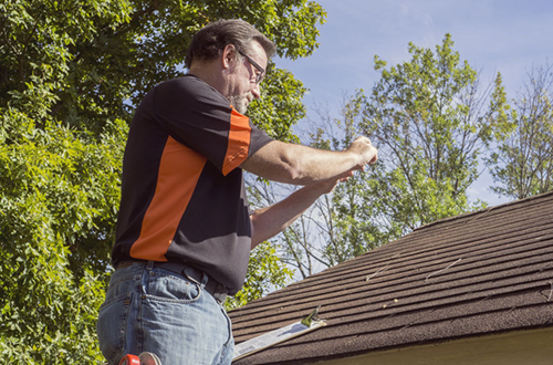 Man taking photos of a damaged roof