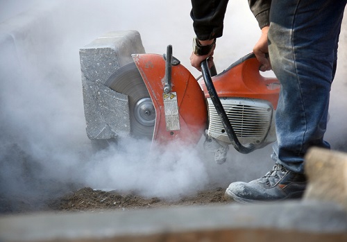 Worker cutting concrete with a saw